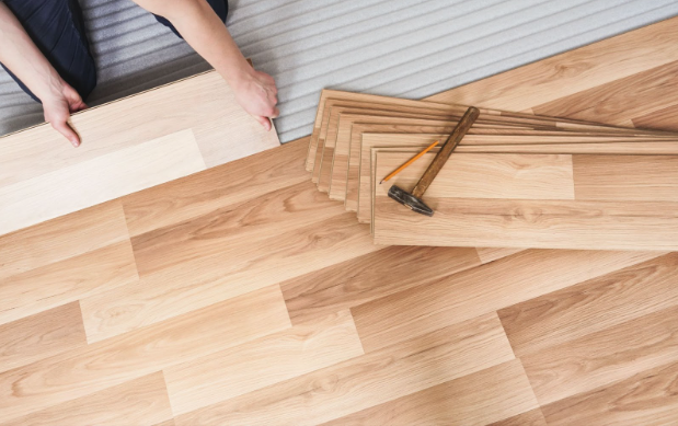 A person installing wood flooring in Utah Laminate Flooring, a discount floor outlet in Utah.