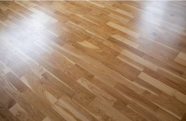 A man laying wood flooring in a room