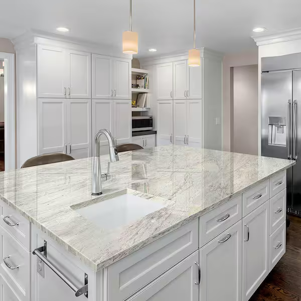 A modern kitchen featuring white cabinets and honed granite countertops, showcasing delicatus white and blanco leblon granite.